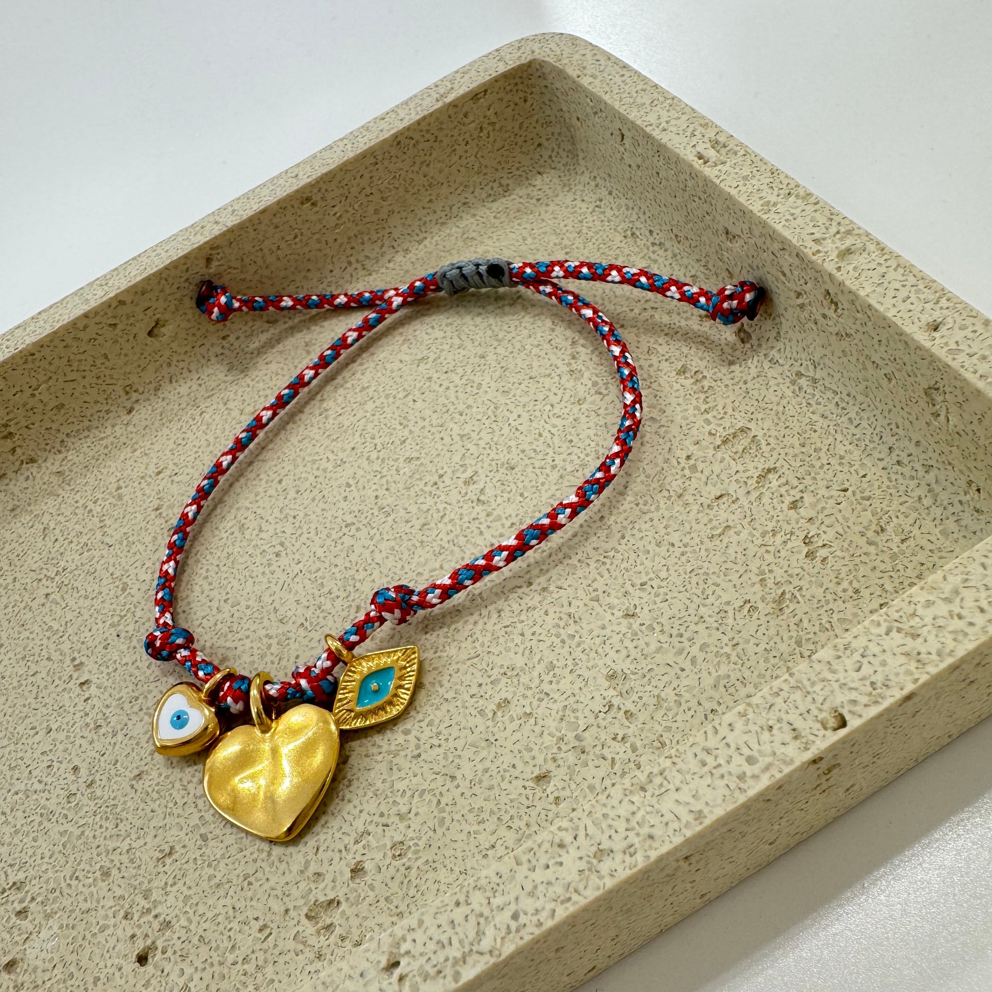 Bracelet with heart-shaped charms on a red cord